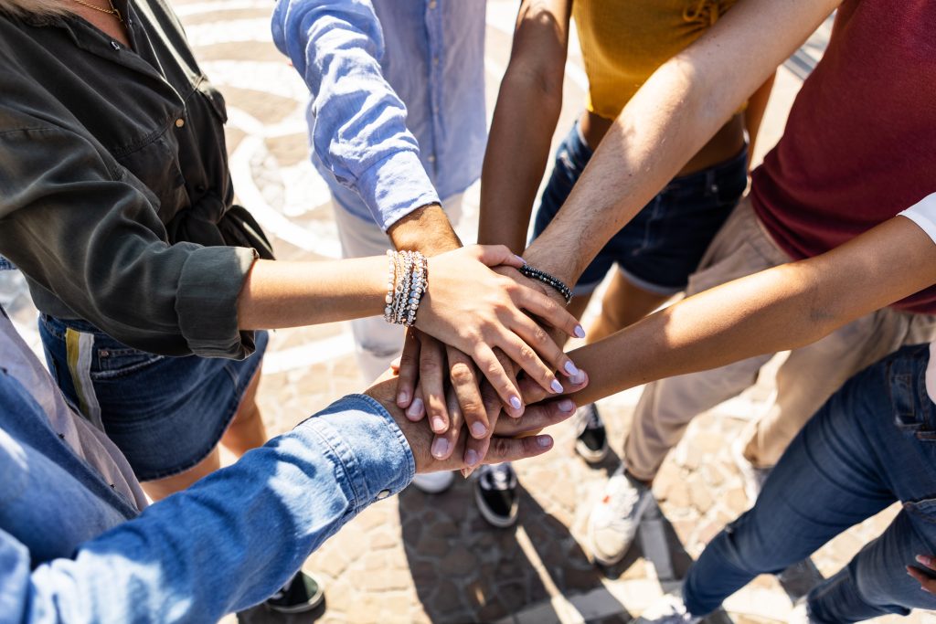 High angle view of multiracial friends stacking hands